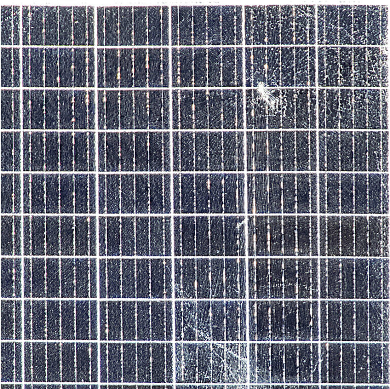 Das Bild zeigt ein PV-Modul im hochauflösenden optischen Bild bei der Drohneninspektion. Gut sichtbar ist ein konzentrischer Glasbruch oben rechts aber auch weitere Bruchlinien Mitte unten. Das ist das typische Schadensbild von einem Hagelschaden mit mehreren Treffern. Bei einer Dach-PV-Anlage ist so ein Schaden von unten meist nicht sichtbar und die elektrische Leistung des Moduls über längere Zeit noch nicht beeinträchtigt. Daher ist ein Solar-PV-Check nach einem Hagel mit großen Körnern sehr zu empfehlen damit die Meldefrist der Hagelversicherung nicht verstreicht.