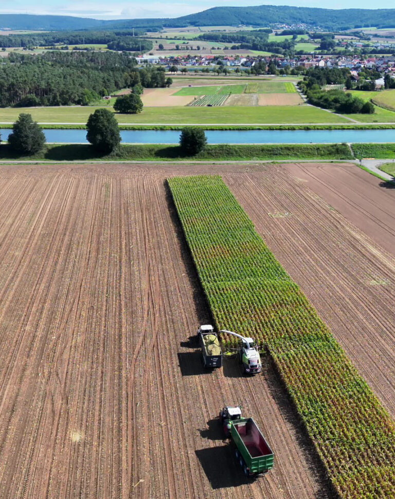 Ein Harvester und 2 Muldenkipper ernten ein Maisfeld vor dem Main-Donau-Kanal. Das Luftbild und ein Video wurden von der DrohnenVisite im Auftrag eines Kunden erstellt.