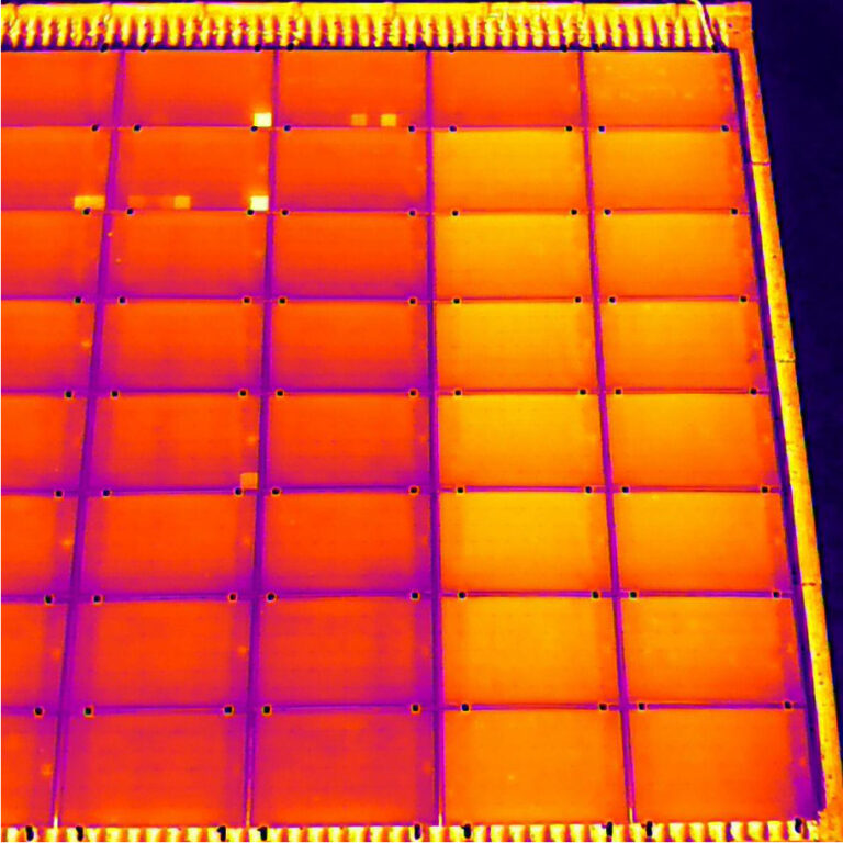 Das Bild zeigt ein PV-Dach im Wärmebild bei der Drohneninspektion. Rechts sind 15 PV-Module heller, d.h. Wärmer als die Linken. Das deutet auf einen String-Fehler hin der z.B. durch fehlerhafte Verkabelung verursacht wird.